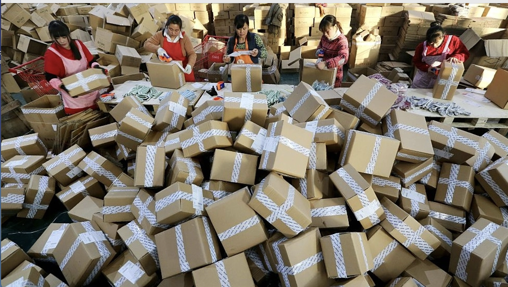 Factory workers with large pile of cardboard boxes